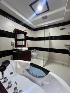 a bathroom with a sink and a bath tub at Pon Arena Hotel in Muang Không