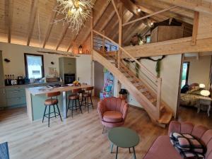 une cuisine et un salon avec un escalier dans une maison dans l'établissement Le Ptit Nid Sous le Chêne, à Xamontarupt
