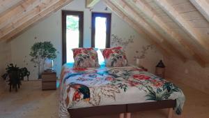 une chambre avec un lit avec une couette colorée dans l'établissement Le Ptit Nid Sous le Chêne, à Xamontarupt