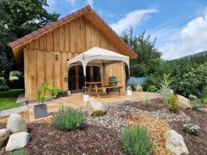 une cabane en bois avec une tente dans un jardin dans l'établissement Le Ptit Nid Sous le Chêne, à Xamontarupt