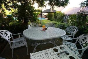 una mesa blanca y sillas blancas y una sombrilla en Stellenbosch Berg, en Stellenbosch