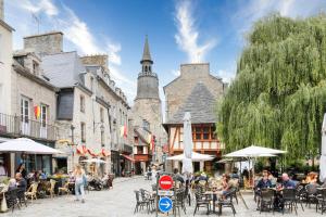 Un groupe de personnes assises à des tables dans une rue de la ville dans l'établissement Le Loft Arvor et son Cosy Lodge, à Dinan