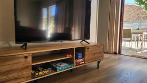 a flat screen tv sitting on top of a wooden entertainment center at The Hamlet House in Prince Alfreds Hamlet