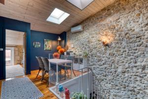 a dining room with a stone wall and a table at Calmacé in Gignac