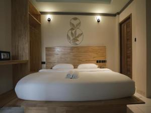 een slaapkamer met een groot wit bed met twee handdoeken bij Wish Maamigili in Maamigili +19 foto's