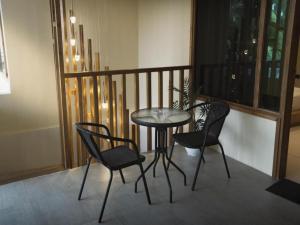 een tafel en vier stoelen op een balkon bij Wish Maamigili in Maamigili