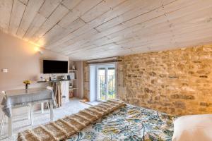a room with a bed and a stone wall at Calmacé in Gignac