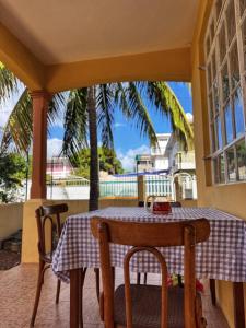 a table and chairs on a porch with a palm tree at 毛里求斯民宿 in Roche Bois