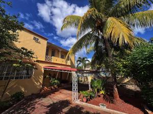 a palm tree next to a building with a gate at 毛里求斯民宿 in Roche Bois