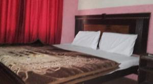 a bedroom with a bed with red curtains at Abu Dhabi Palace in Dargai
