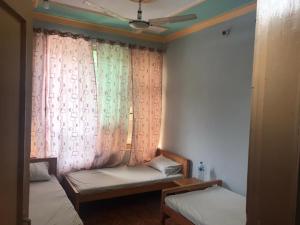a room with two beds and a window with curtains at Abu Dhabi Palace in Dargai