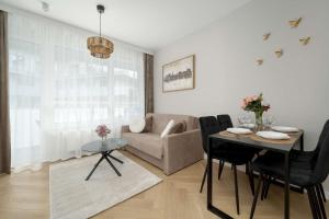 ein Wohnzimmer mit Tisch und Couch in der Unterkunft Elegant Apartments Mieszczańska Wrocław with Air Conditioning, Spa & Gym by Renters Prestige in Breslau
