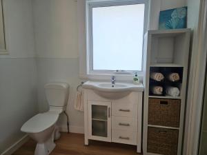 a bathroom with a sink and a toilet and a window at Port Sorell Beach Shack in Port Sorell +9 photos