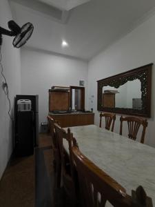 een eetkamer met een tafel, stoelen en een spiegel bij Daffodil House Proper Guest House Near Malioboro in Demangan