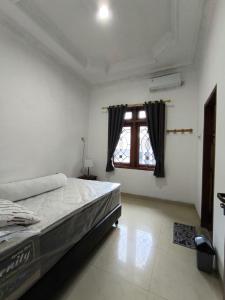 een slaapkamer met een groot bed en een raam bij Daffodil House Proper Guest House Near Malioboro in Demangan