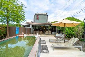 員山郷にある蘭庭 Villa民宿 B&Bの家の隣に椅子とパラソル付きのプールがあります。