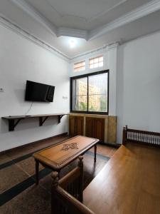 een kamer met een tafel en een flatscreen-tv bij Daffodil House Proper Guest House Near Malioboro in Demangan