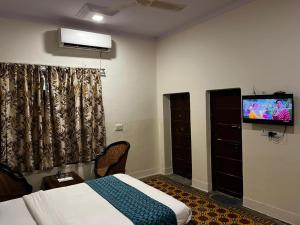 a bedroom with a bed and a flat screen tv at Crown Plaza Heritage in Jodhpur