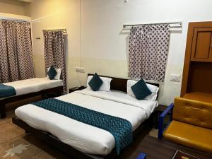 a hotel room with two beds and a chair at Crown Plaza Heritage in Jodhpur