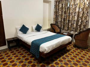 a bedroom with a bed with blue pillows on it at Crown Plaza Heritage in Jodhpur +4 photos