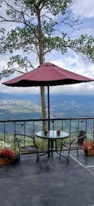 a table and two chairs under an umbrella at Glamping Mirador de Tibacuy in El Cape