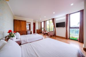 a hotel room with two beds and a television at Thu Ha Hotel in Uông Bí +120 photos