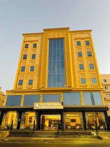 een groot geel gebouw met een bord ervoor bij Dimond Vision Hotel in Jeddah +11 foto's
