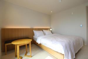 a bedroom with a bed and a wooden table at Hotel Boreum in Sach'ŏnjil-li +16 photos