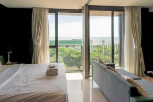 a bedroom with a bed and a view of the ocean at Seaphere Residence by Prop Hopper in Na Jomtien