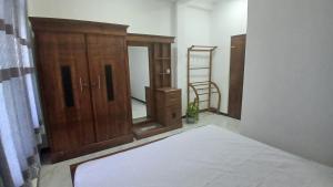 ein Schlafzimmer mit einem Bett und einem Holzschrank in der Unterkunft Luna Villa in Mawadawila + 15 Fotos