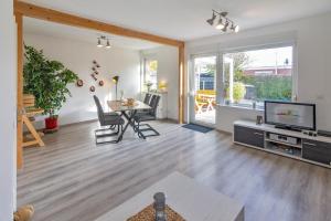 a living room with a table and a television at Deichgraf in Dornumersiel