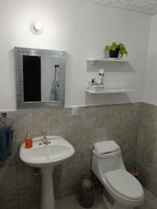 a bathroom with a sink and a toilet and a mirror at Casa Mariscal in Guatemala +14 photos