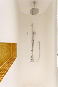 a bathroom with a shower and a yellow tile wall at Skyline View Vienna - Gym - Parken - Supermarkt - Restaurant - Self Check in in Vienna +12 photos