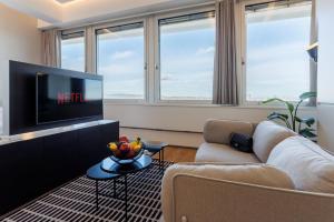 a living room with a couch and a tv at Skyline View Vienna - Gym - Parken - Supermarkt - Restaurant - Self Check in in Vienna