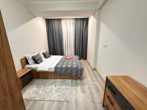 a small bedroom with a bed and a window at Duet in Bishkek