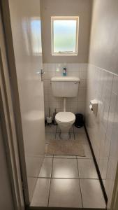 a small bathroom with a toilet and a window at The Hamlet House in Prince Alfreds Hamlet +20 photos