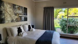 a bedroom with a bed with two cats on it at The Hamlet House in Prince Alfreds Hamlet