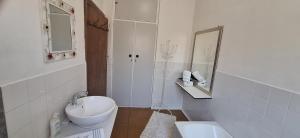 Un baño con lavabo, inodoro y espejo. en Mitat Guesthouse, en Beaufort West 48 fotos más