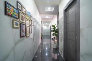a hallway with paintings on the wall and a hallway with a door at FabHotel Frendz - Nr Hitech City Metro Station in Jāmb