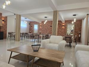 ein Wohnzimmer mit Tisch und Stühlen und einer Backsteinwand in der Unterkunft Dwór Bysina in Myślenice