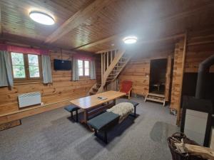 a room with a table and chairs and a staircase at Chalupa Pod lomem - Malá in Dolní Morava