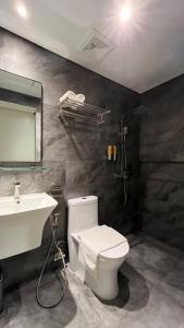 a bathroom with a white toilet and a sink at Vibe Hotel Alabang in Manila
