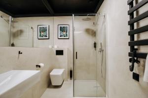 a bathroom with a shower and a toilet and a sink at Hotel Cztery Pory Roku in Głogów Małopolski +18 photos