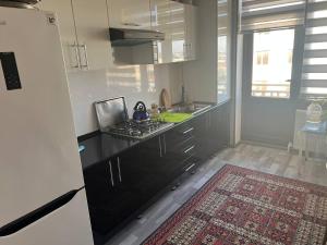 a kitchen with a black counter top and a refrigerator at Квартира Комфорт in Samarkand