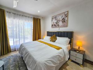 una camera da letto con un grande letto bianco e una finestra di On The Moon Hospitality and Conference Facility a East London Altre 157 foto