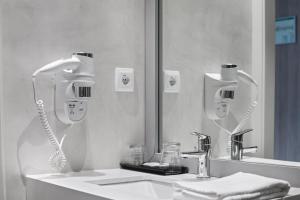 a bathroom sink with a hair dryer and a mirror at Augusta Barcelona Vallès in Granollers