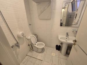 a white bathroom with a toilet and a sink at الجوهرة سويت للشقق المخدومة in Shahār +63 photos