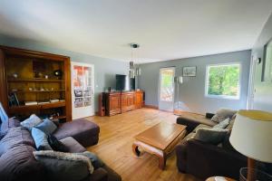 a living room with two couches and a coffee table at Villa paisible avec piscine in Bercloux