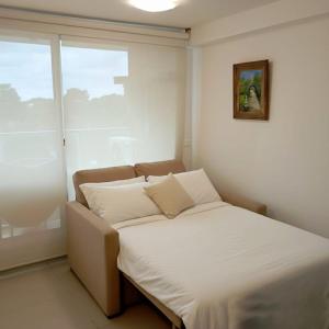 a bed in a small room with a window at Apartamento Acapulco in Punta del Este