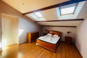 une chambre mansardée avec un lit avec une lucarne dans l'établissement Villa paisible avec piscine, à Bercloux